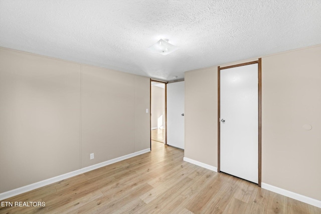 unfurnished bedroom with a textured ceiling and light hardwood / wood-style floors