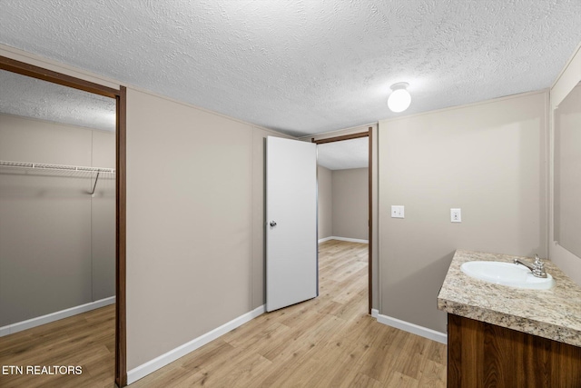 bathroom featuring hardwood / wood-style floors, vanity, and a textured ceiling