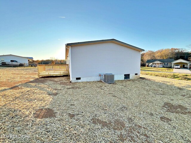 view of home's exterior with central AC unit and a wooden deck