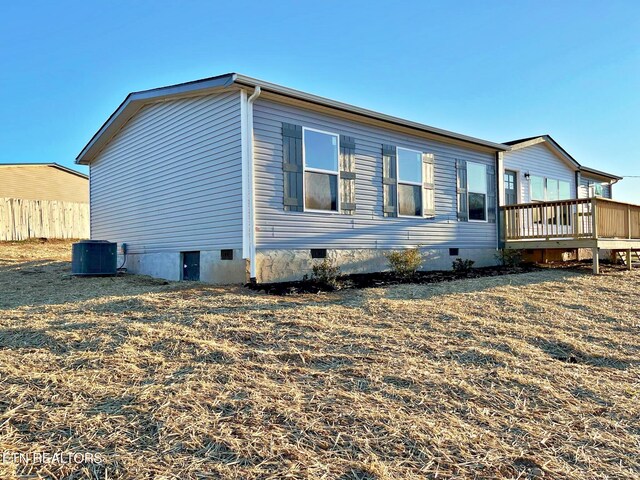 back of house featuring central air condition unit and a deck