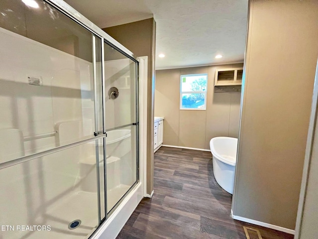 bathroom with wood-type flooring, vanity, and independent shower and bath