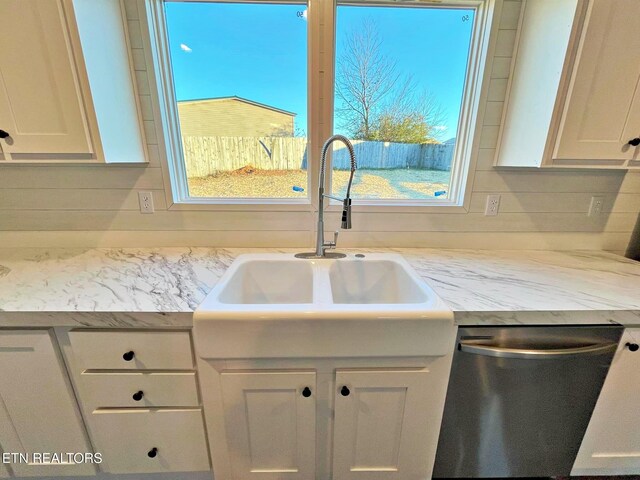 kitchen featuring stainless steel dishwasher, decorative backsplash, white cabinets, and sink