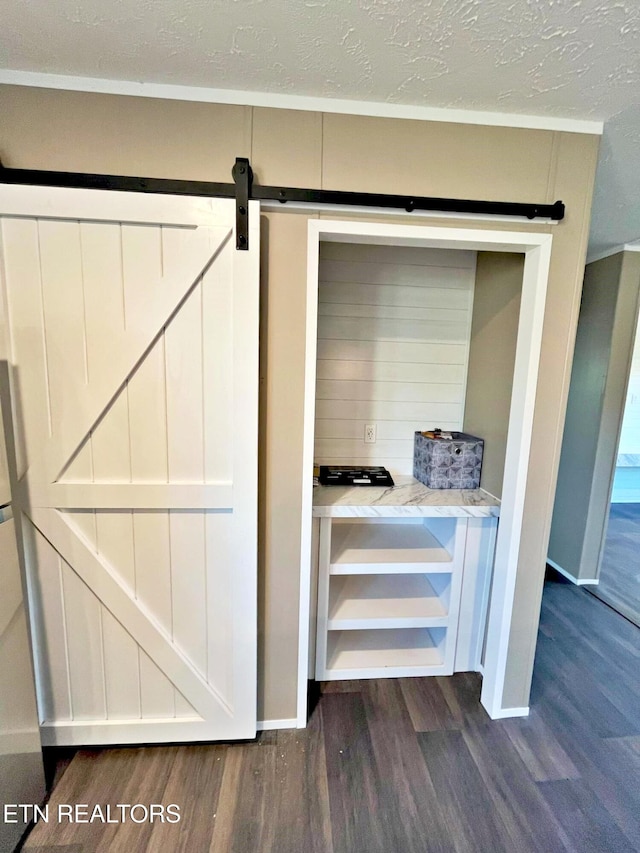 interior details featuring a barn door and hardwood / wood-style floors