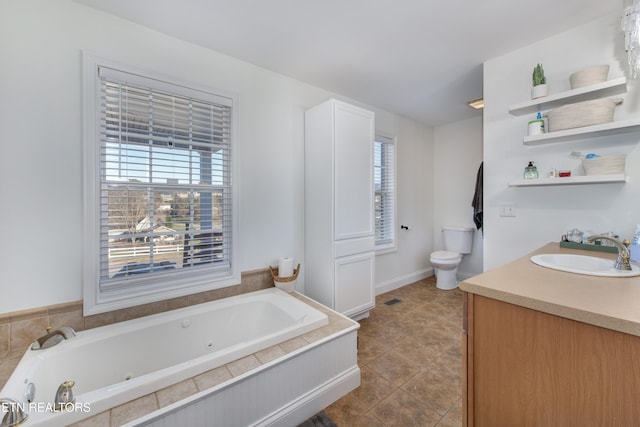 bathroom with vanity, plenty of natural light, a bathing tub, and toilet