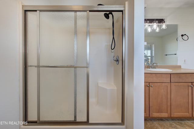 bathroom featuring vanity and a shower with door