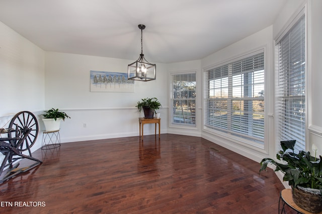 dining area with dark hardwood / wood-style flooring and an inviting chandelier