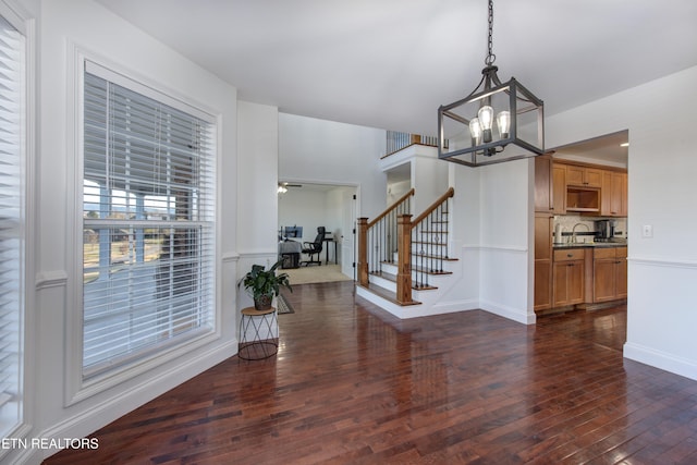 entryway with a notable chandelier, dark wood-type flooring, and sink