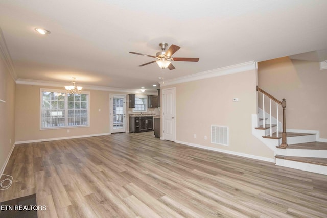 unfurnished living room featuring crown molding, light hardwood / wood-style flooring, and ceiling fan with notable chandelier