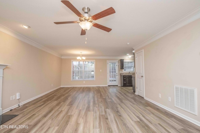 unfurnished living room featuring ceiling fan with notable chandelier, light hardwood / wood-style floors, and crown molding