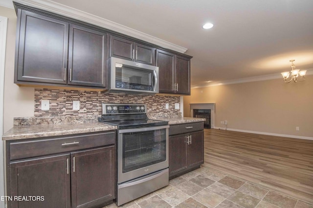 kitchen with decorative backsplash, stainless steel appliances, crown molding, light hardwood / wood-style flooring, and a notable chandelier