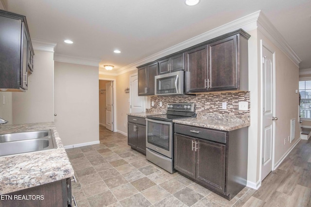 kitchen featuring dark brown cabinetry, crown molding, sink, and appliances with stainless steel finishes