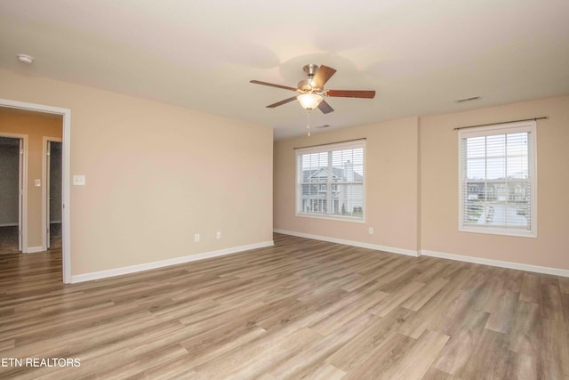 spare room featuring light hardwood / wood-style floors, plenty of natural light, and ceiling fan