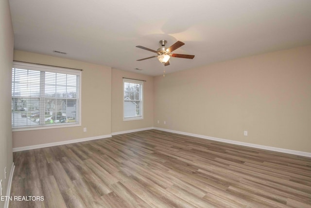 unfurnished room with hardwood / wood-style flooring and ceiling fan