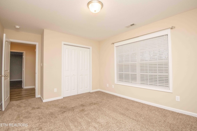 unfurnished bedroom with carpet flooring and a closet