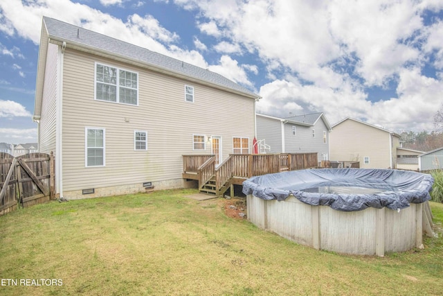 back of house featuring a swimming pool side deck and a lawn