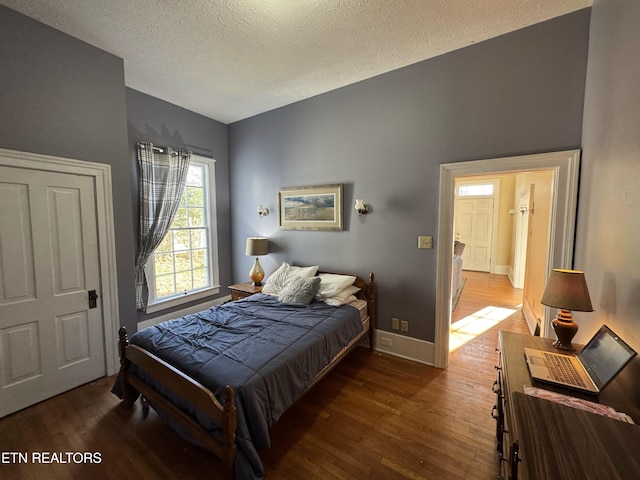 bedroom featuring a textured ceiling and dark hardwood / wood-style floors