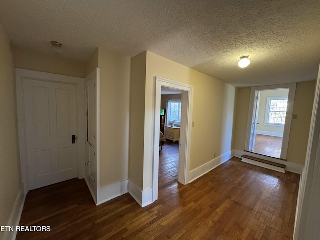 corridor featuring dark hardwood / wood-style floors and a textured ceiling