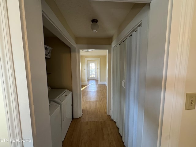 hall with hardwood / wood-style flooring and washer and clothes dryer