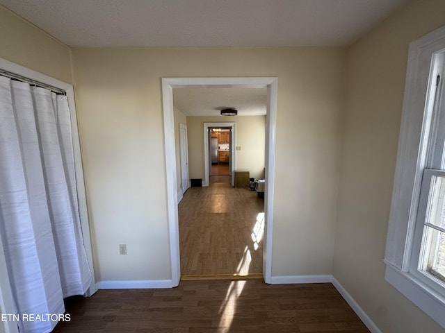 hall featuring a textured ceiling and dark wood-type flooring