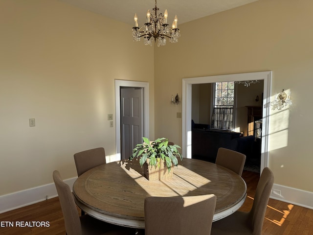 dining space with dark hardwood / wood-style floors and an inviting chandelier