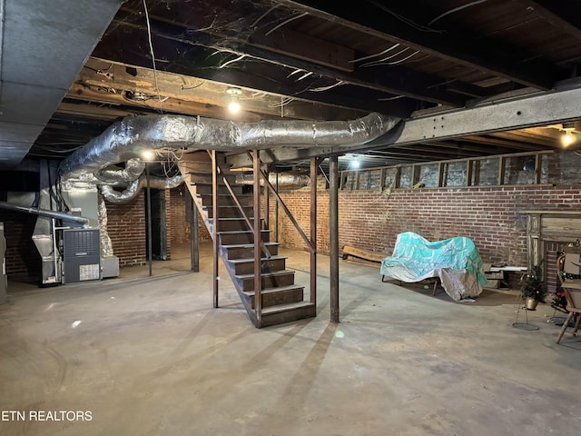 basement featuring heating unit and brick wall