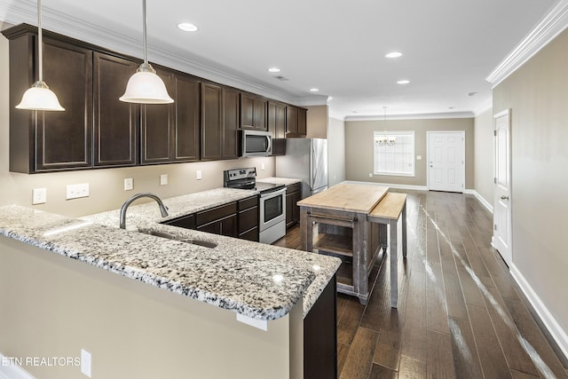 kitchen with dark wood-type flooring, sink, light stone countertops, appliances with stainless steel finishes, and dark brown cabinetry