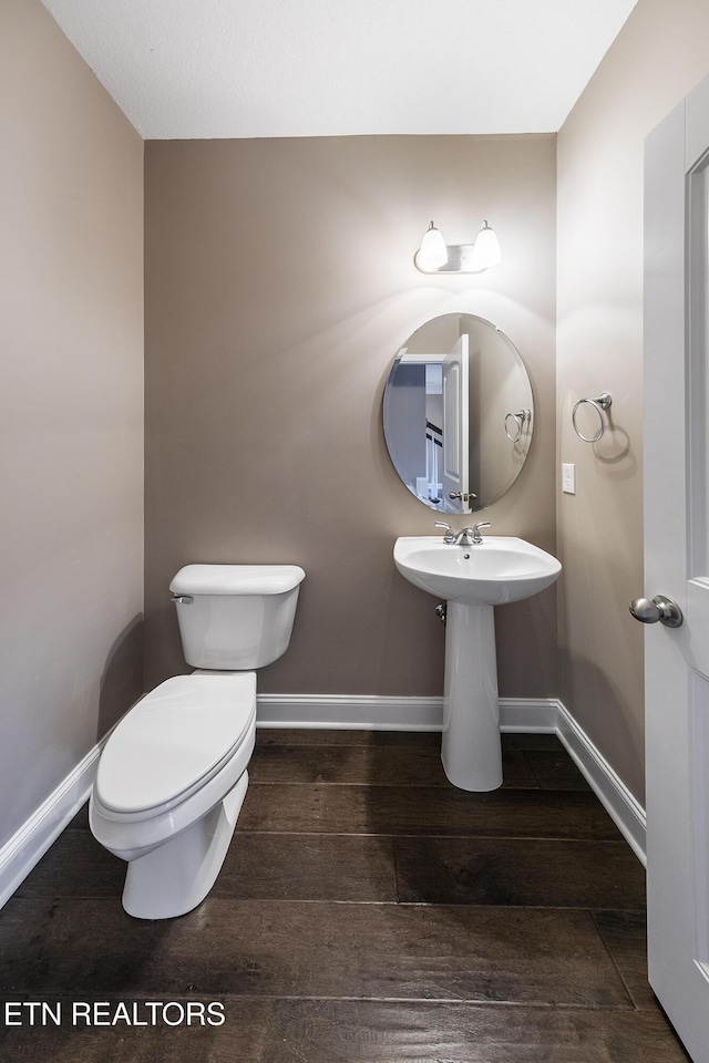 bathroom with hardwood / wood-style floors, toilet, and sink