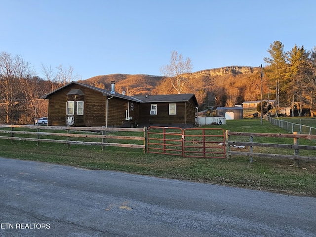 view of front of house featuring a mountain view, a rural view, and a front yard