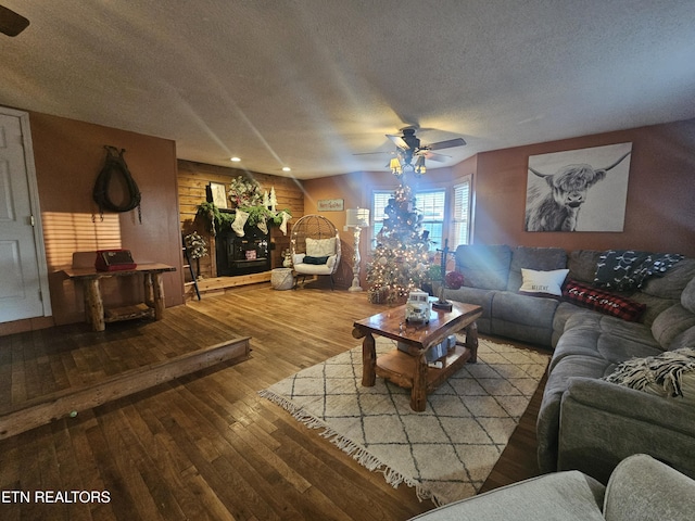 living room featuring hardwood / wood-style floors, ceiling fan, and a textured ceiling