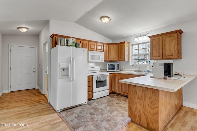 kitchen with sink, kitchen peninsula, light hardwood / wood-style floors, lofted ceiling, and white appliances