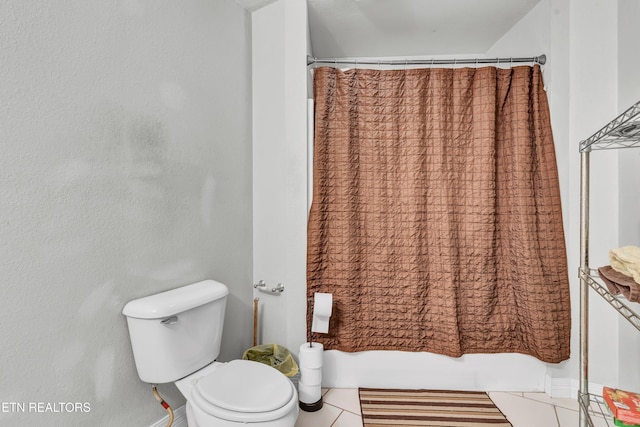 bathroom with tile patterned flooring and toilet