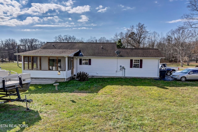 rear view of property with a sunroom and a yard