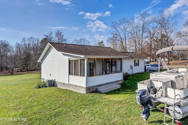 exterior space featuring a lawn, central AC, and a sunroom