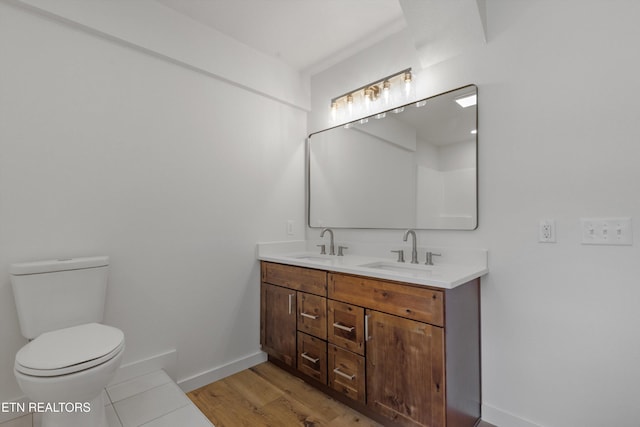 bathroom featuring toilet, vanity, and hardwood / wood-style flooring