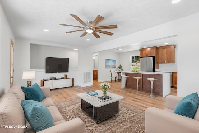 living room with ceiling fan and light wood-type flooring