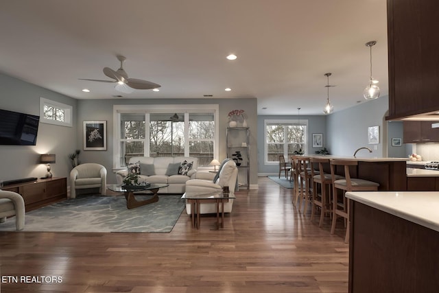 living room featuring hardwood / wood-style floors and ceiling fan