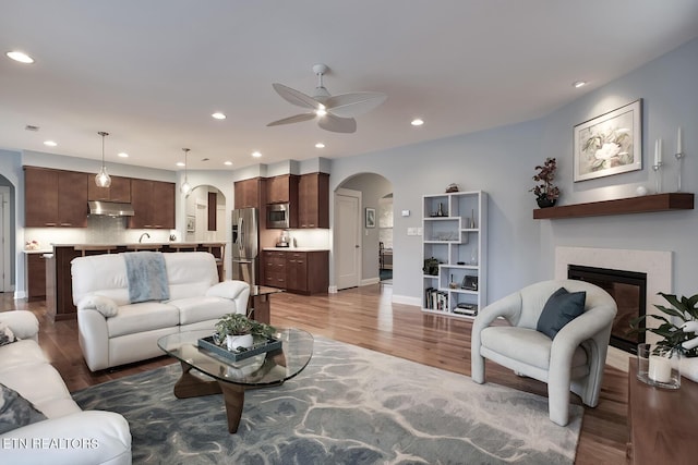 living room with light hardwood / wood-style floors and ceiling fan