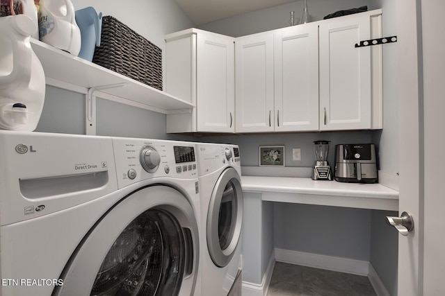 washroom with cabinets and washing machine and clothes dryer