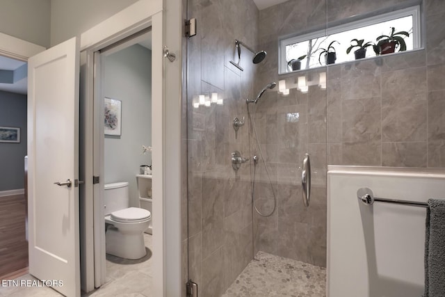 bathroom featuring toilet and a shower with shower door