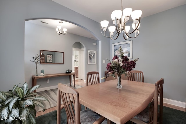 dining room featuring hardwood / wood-style floors and a chandelier