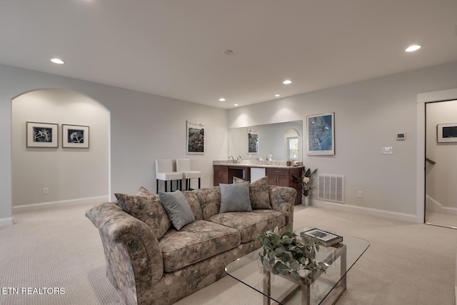 living room featuring bar and light colored carpet