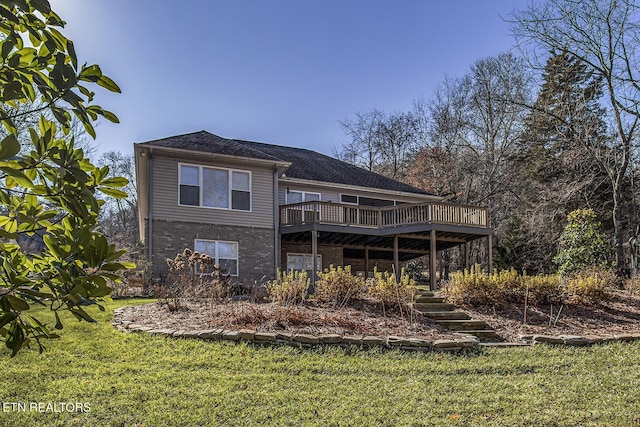 rear view of property with a wooden deck and a lawn