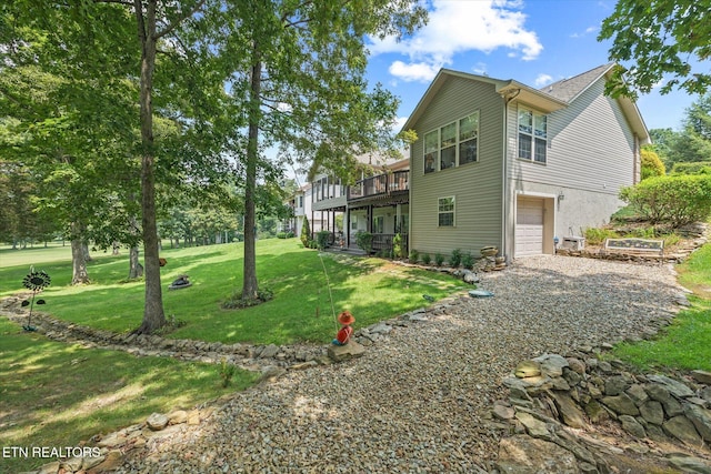 exterior space featuring a yard, a deck, and a garage