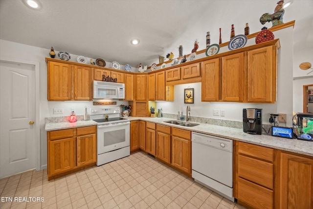 kitchen with light stone countertops, sink, and white appliances