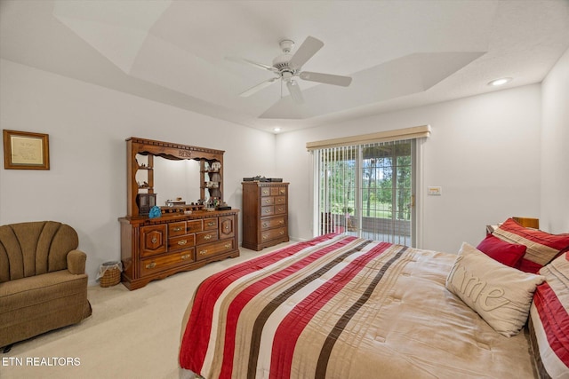 carpeted bedroom with access to outside, ceiling fan, and a tray ceiling