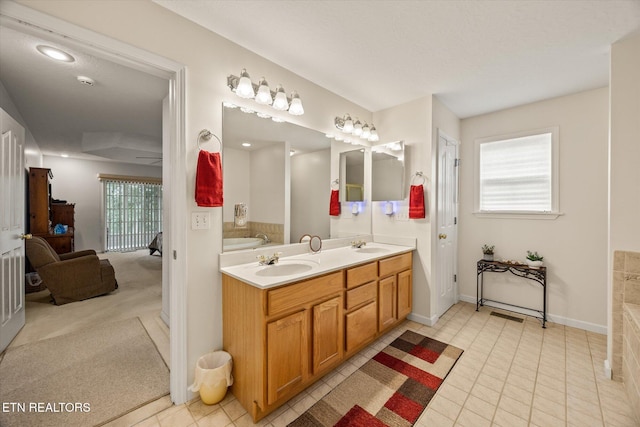 bathroom with tile patterned flooring, a bath, and vanity