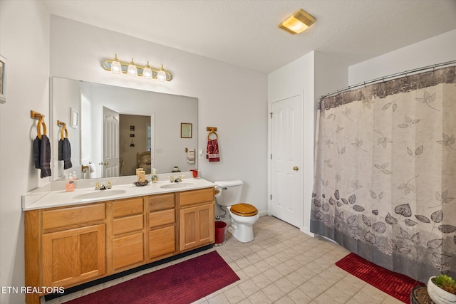 bathroom with vanity, a textured ceiling, and toilet