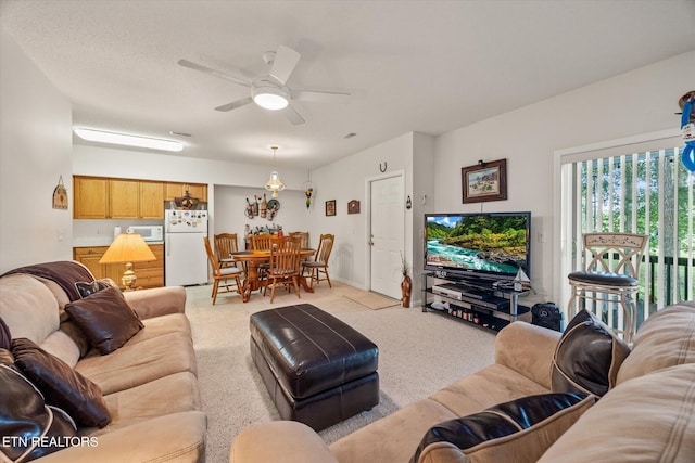 living room with ceiling fan and light colored carpet