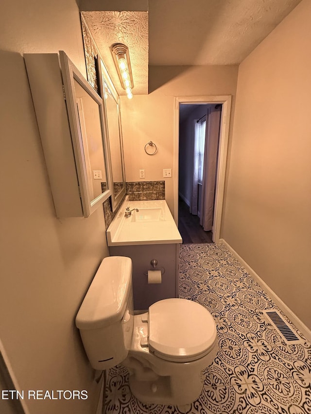 bathroom featuring tile patterned floors, vanity, a textured ceiling, and toilet