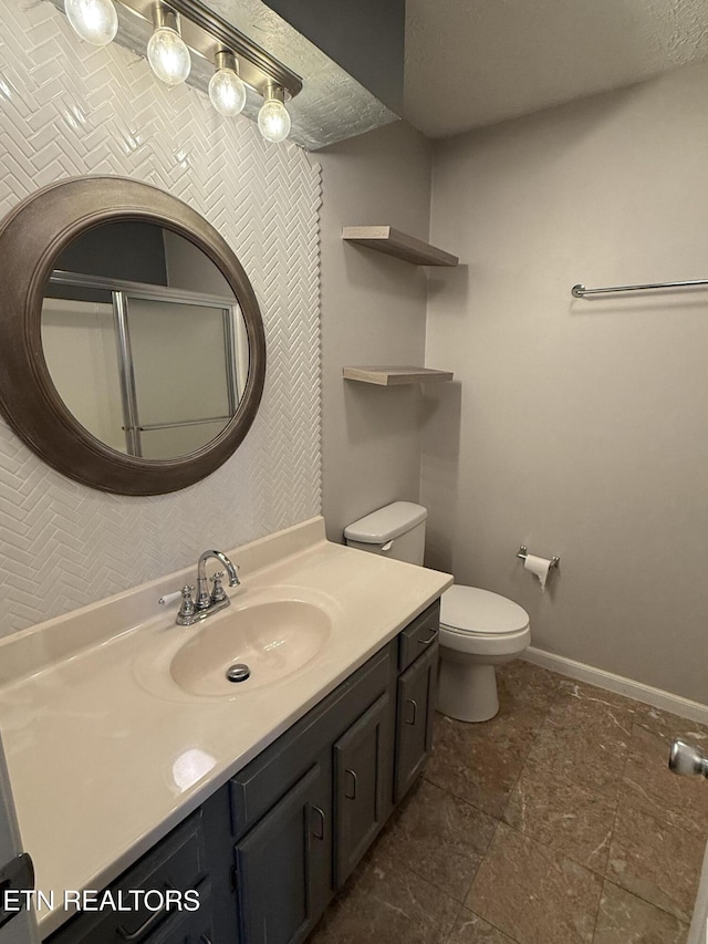 bathroom featuring vanity, a textured ceiling, and toilet